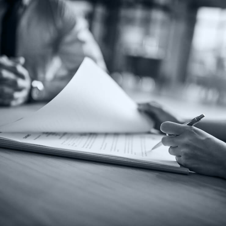 Two people signing papers